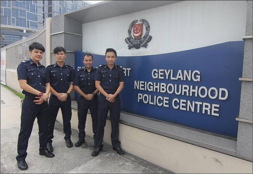Police officers pose outside a police station in Geylang, Singapore