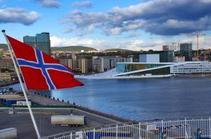 The Norwegian flag flying in front of the Oslo Opera House