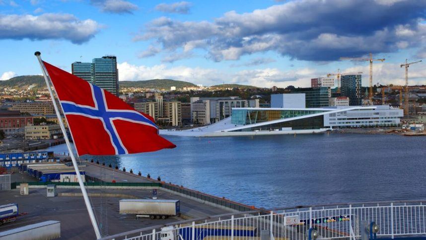 The Norwegian flag flying in front of the Oslo Opera House