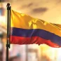 The flag of Colombia against a backdrop of the sun