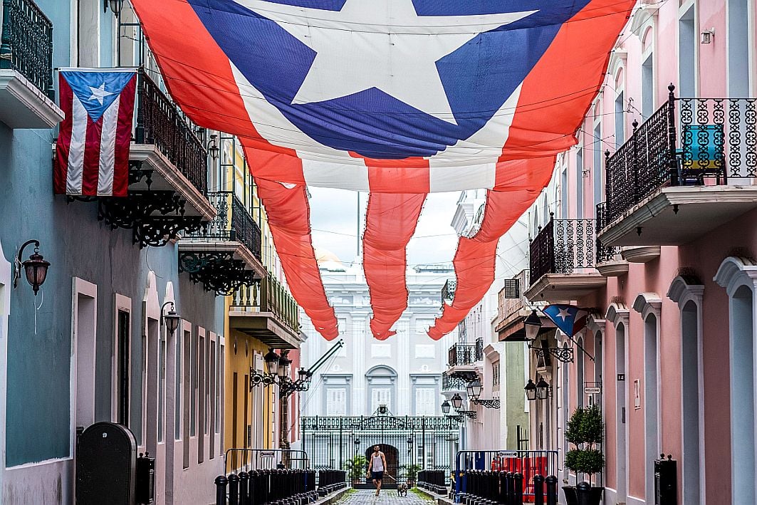 The governor's mansion of Puerto Rico sits in the background behind the territory's flag