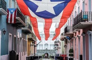 The governor's mansion of Puerto Rico sits in the background behind the territory's flag.