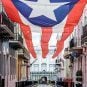 The governor's mansion of Puerto Rico sits in the background behind the territory's flag.
