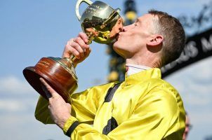 Mark Zahra kisses his trophy after winning the Melbourne Cup on Without A Fight