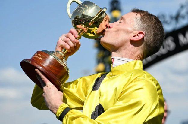 Mark Zahra kisses his trophy after winning the Melbourne Cup on Without A Fight