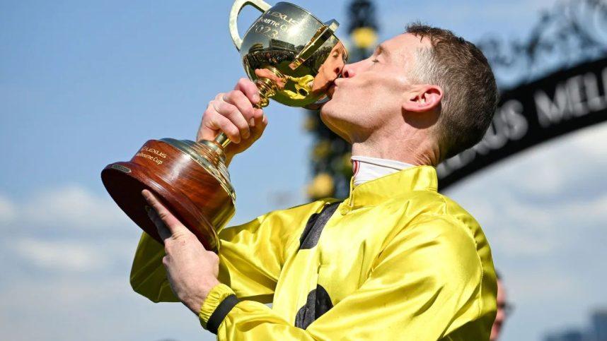 Mark Zahra kisses his trophy after winning the Melbourne Cup on Without A Fight