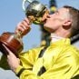 Mark Zahra kisses his trophy after winning the Melbourne Cup on Without A Fight
