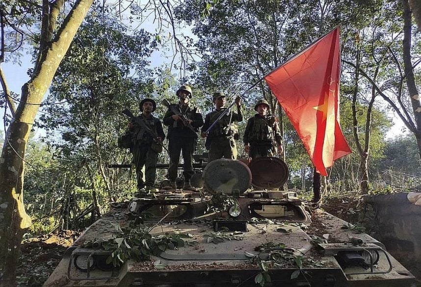 Myanmar National Democratic Alliance Army members pose on a tank they captured from the country's ruling military government