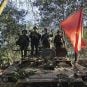 Myanmar National Democratic Alliance Army members pose on a tank they captured from the country's ruling military government