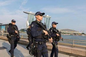 Singapore Police Force officers on patrol against a background of Marina Bay Sands