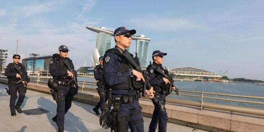 Singapore Police Force officers on patrol against a background of Marina Bay Sands