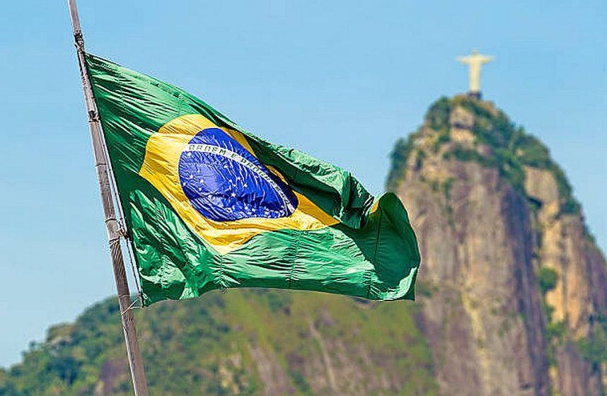 The Brazilian flag flying against a background of the Christ the Redeemer statue