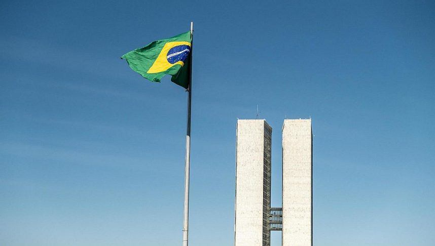 The Brazilian flag flying in front of the National Congress buildings
