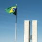 The Brazilian flag flying in front of the National Congress buildings