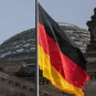 The German flag flies against a background of the dome of the Reichstag building in Berlin