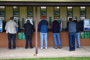 Bettors place wagers on races through TAB betting kiosks in Australia