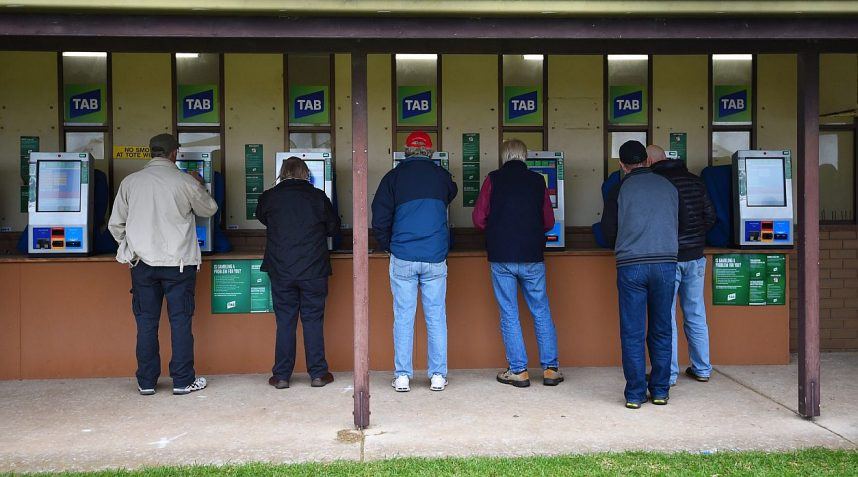 Bettors place bets on races through TAB betting kiosks in Australia