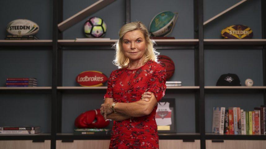 Entain CEO Jette Nygaard-Andersen poses with a bookcase of sports memorabilia