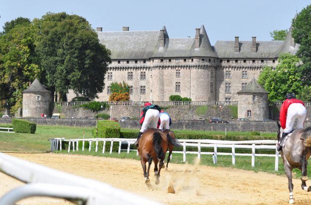 Jockeys riding horses at the Haras National de Pompadour stud farm in France