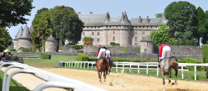 Jockeys riding horses at the Haras National de Pompadour stud farm in France