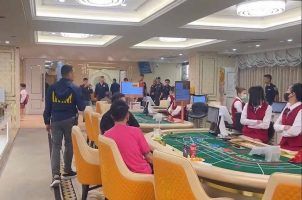 Police officers conduct a raid of an illegal casino in Thailand