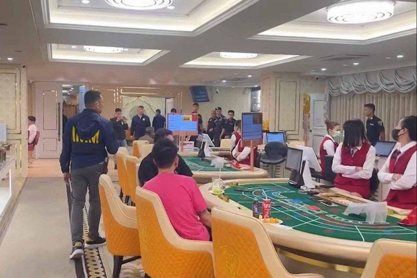 Police officers conduct a raid of an illegal casino in Thailand