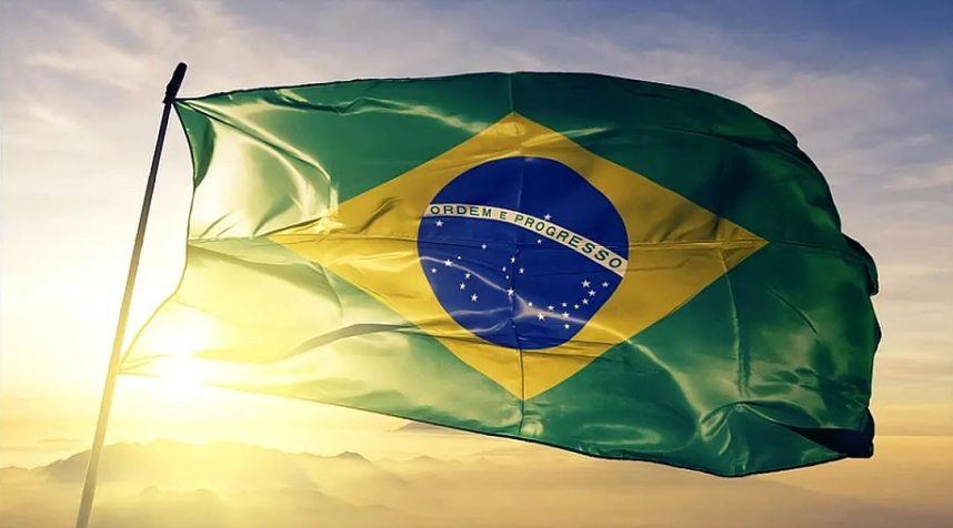 The Brazilian flag flying against a backdrop of the sun