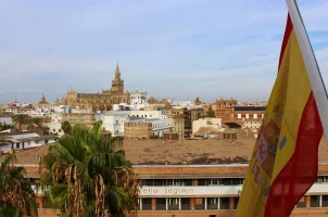 The Spanish flag flies against the background of the Cathedral of Seville in Seville, Spain