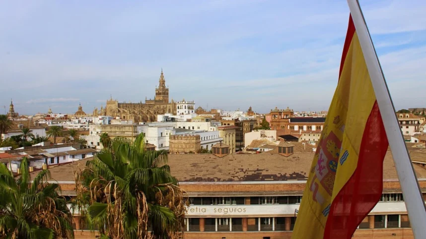 The Spanish flag flies against the background of the Cathedral of Seville in Seville, Spain