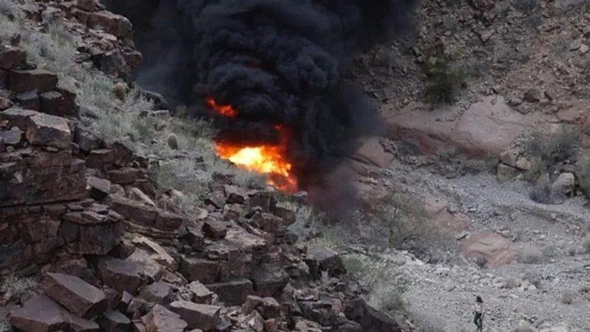 A helicopter burns after crashing on the west rim of the Grand Canyon o